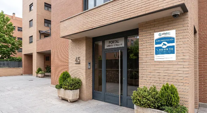 Cámara y cartel disasorio instalado en portal de zona exterior del edificio